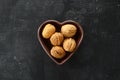 Inshell walnuts in a heart-shaped plate. Heart Nuts, Heart Health Products, Structured Walnuts Healthy food protein Royalty Free Stock Photo