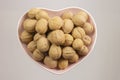 Inshell walnuts in a heart-shaped plate. Heart Nuts, Heart Health Products, Structured Walnuts Royalty Free Stock Photo