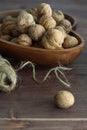 Inshell walnuts lie in a wooden dish, next to twine and a hammer for cracking nuts Royalty Free Stock Photo