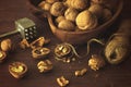 Inshell walnuts lie in a wooden dish, next to twine and a hammer for cracking nuts Royalty Free Stock Photo