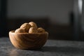 Inshell walnuts in olive wood bowl on terrazzo countertop Royalty Free Stock Photo