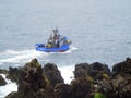 Inshore fishing vessel sailing close to rocks Royalty Free Stock Photo