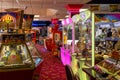 The inside of an amusement arcade with grabber machines, two pence machines and slot machines