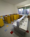 Inside a bathroom of a nursery school with small toilets and sin