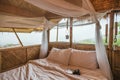 Inside the bedroom that made of wooden thatched with mosquito net, book, retro camera among the mountain