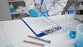 Inside the buzz of the lab, hands of dedicated woman scientist working diligently, taking critical notes amid medical research