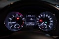 Inside the car, close-up of a circular dashboard, speedometer and tachometer with white backlighting. Royalty Free Stock Photo