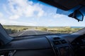 Inside of car with dashboard driving down coastal road Royalty Free Stock Photo