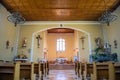 Inside a Christian Church with wooden chairs, and statues of Jesus hung on the walls