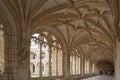 inside the cloister of the convent of the Jeronimos, with its decorated gothic arches, and tourists in the background visiting it Royalty Free Stock Photo