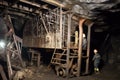 inside a coal mine, with miners using and drilling equipment to extract the resource