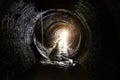 Inside dark round underground sewer tunnel