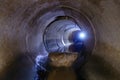 Inside dark round underground urban sewer tunnel