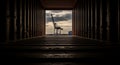 Inside a dark shipping container looking out at a crane in a freight yard at dusk Royalty Free Stock Photo
