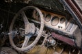 Inside the dashboard of an old car with dust and dirt on it.