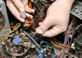 Inside details of the old personal computer. Cooler, motherboard, wires and video card in the dust. Man is holding cables in his Royalty Free Stock Photo