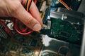 Inside details of the old personal computer. Cooler, motherboard, wires and video card in the dust. Man is holding hard disk drive Royalty Free Stock Photo