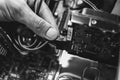 Inside details of the old personal computer. Cooler, motherboard, wires and video card in the dust. Man is holding hard disk drive Royalty Free Stock Photo