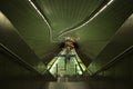 Inside of an escalator, showcasing the illuminated staircase and the long, winding corridor below.