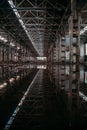 Inside of flooded dirty abandoned ruined industrial building with water reflection