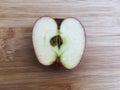 Inside ripe red apple half piece slice on wooden background