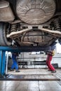 Inside a garage - two mechanics working on a car