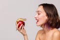 Inside. Girl holding in hand an apple on which sits an iguana gecko. Royalty Free Stock Photo