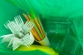 Inside of green plastic bag with single use cutlery and packages