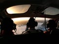 Inside helicopter, pilot and 2 passengers taken from the rear seat of helicopter