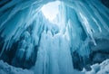 Inside an ice cave with icicles and sky visible through opening Royalty Free Stock Photo
