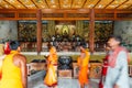 Inside Indosan Nippon Japanese Temple, Lord Buddha statue in the center with wall painted and wooden ceiling with Indian people.