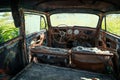 Inside interior of Old retro rusty abandoned car overgrown with grass, close up Royalty Free Stock Photo