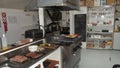 Inside of a kitchen in a small Restaurant with a lot of kitchenware, oven and some food Royalty Free Stock Photo