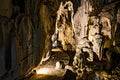 Inside a long cave with pointy walls and a walking trai. Stunning landscape with stalagmites and stalactites in the Trung Trang