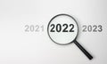 2022 inside of Magnifier glass on white background for focus current situation, positive thinking mindset concept. 2022 in focus.