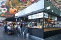 Inside market hall showing food court area with customers and tourists. Pinchos take out cafe