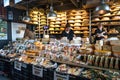 Inside market hall showing food court area with display of cheese for sale at vendor stall