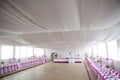 The inside of a massive white wedding tent with ta