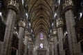 Inside the Milan Cathedral, Italy. High Gothic cross vault, decorations on ceiling, windows, colored light on pillars and columns. Royalty Free Stock Photo