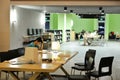 Inside of modern university library, people reading and studying in library hall