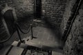 Inside of old creepy abandoned mansion. Staircase and colonnade. Dark castle stairs to the basement. Spooky dungeon stone stairs i