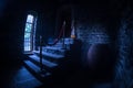 Inside of old creepy abandoned mansion. Staircase and colonnade. Halloween pumpkin on dark castle stairs to the basement. Royalty Free Stock Photo