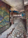 Inside of old creepy abandoned sanatorium. Mosaic and colonnade.