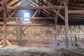 Inside Old Dirty Barn With Hay Bales Dark Wood Beams And Wooden Ladder Streaming Light From Window