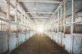 Inside old wooden stable or barn with horse boxes, tunnel or corridor view with light in the end Royalty Free Stock Photo