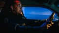 Inside police traffic patrol squad car: black female police officer on duty, receives emergency