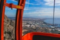 Inside of red cabin of cableway on picturesque mountains. Cabin driving over huge mountains