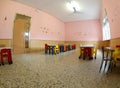 Inside the refectory of a school with small tables and small ch