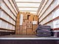 Inside of a removal van, packing boxes and blankets.