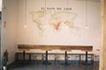 Inside shot of a cafe with round tables and chairs near a map of coffee print on the wall